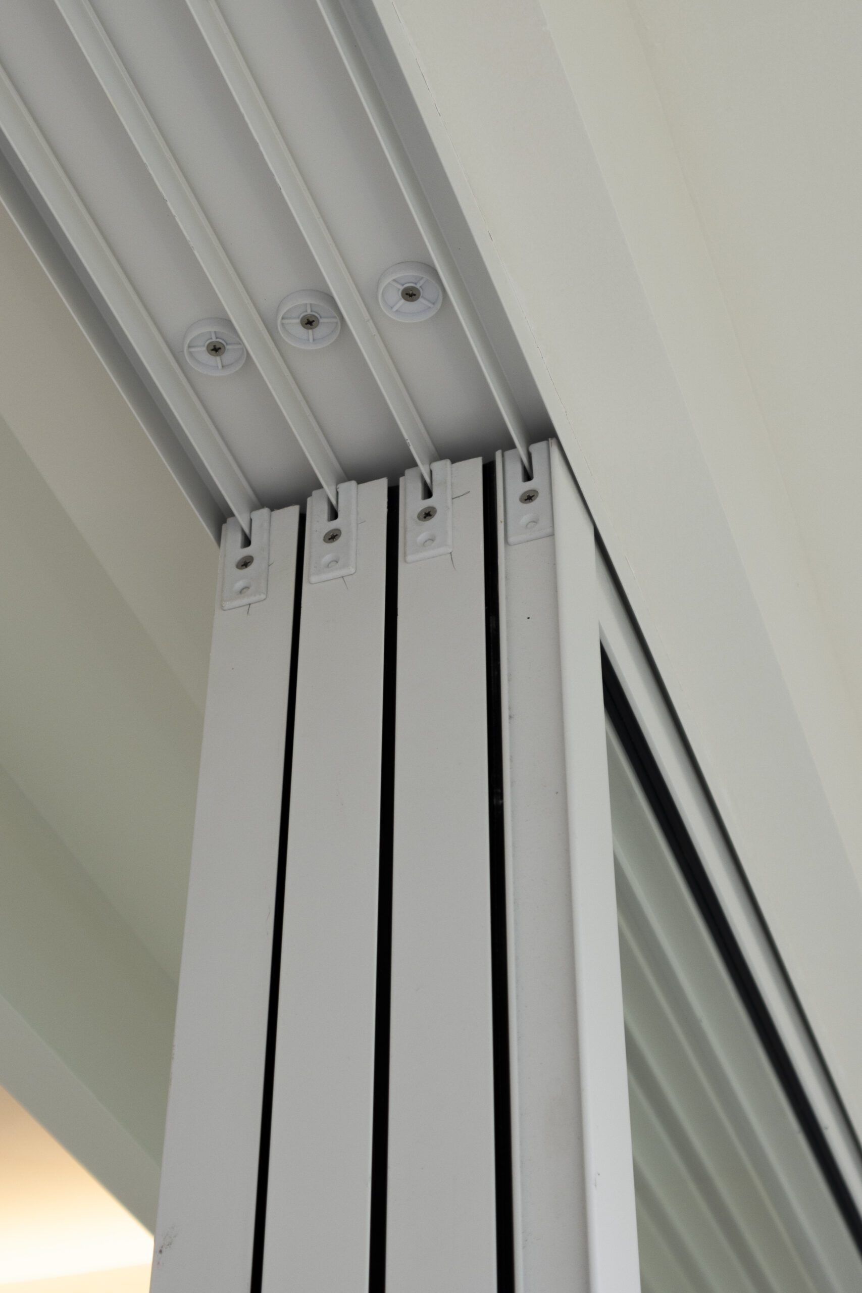 Aluminum window and door installation at Marine Vista with 4-track sliding door and white powder-coated finish