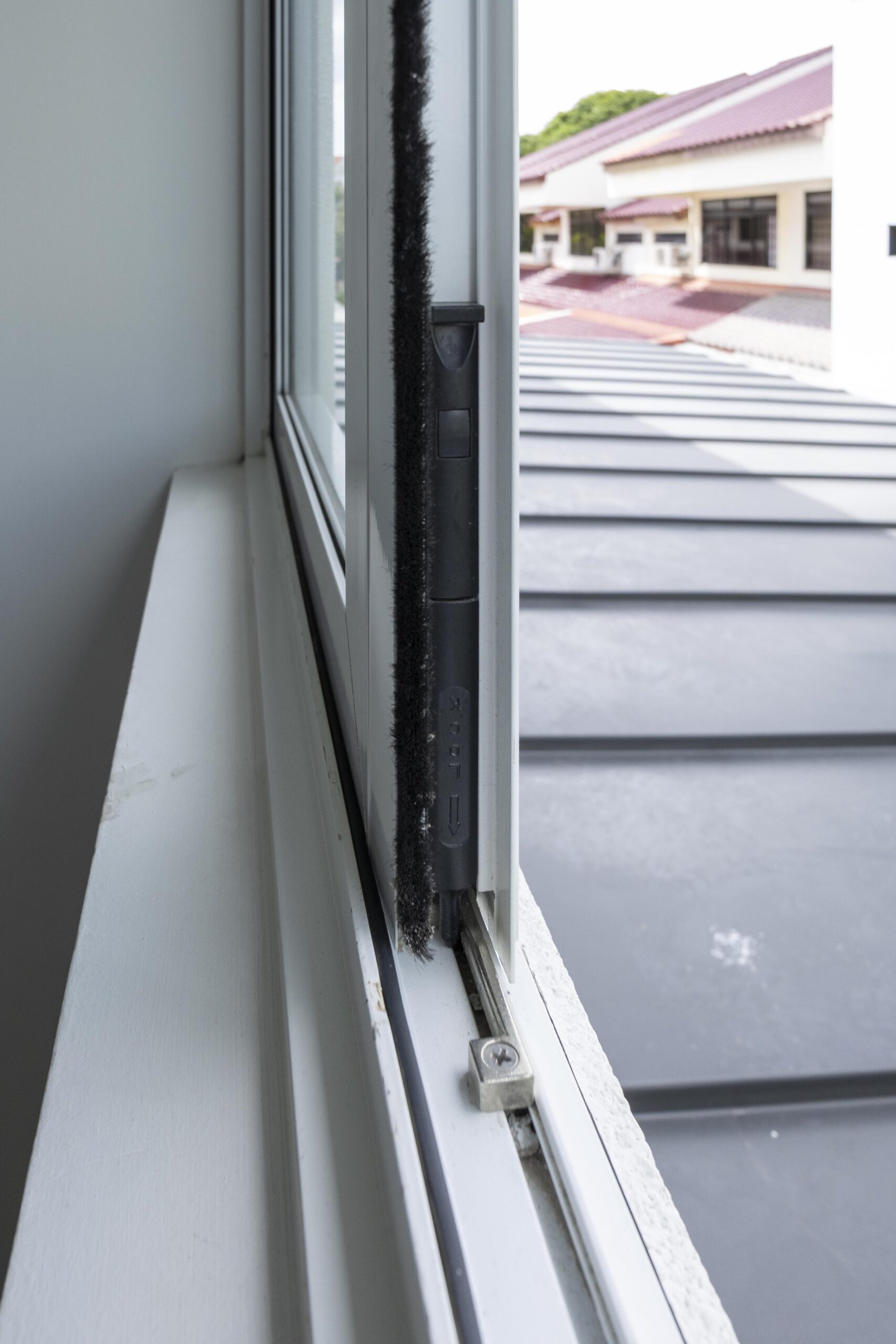 Satin white powder-coated window frame with matte black handles in Bedok Ria