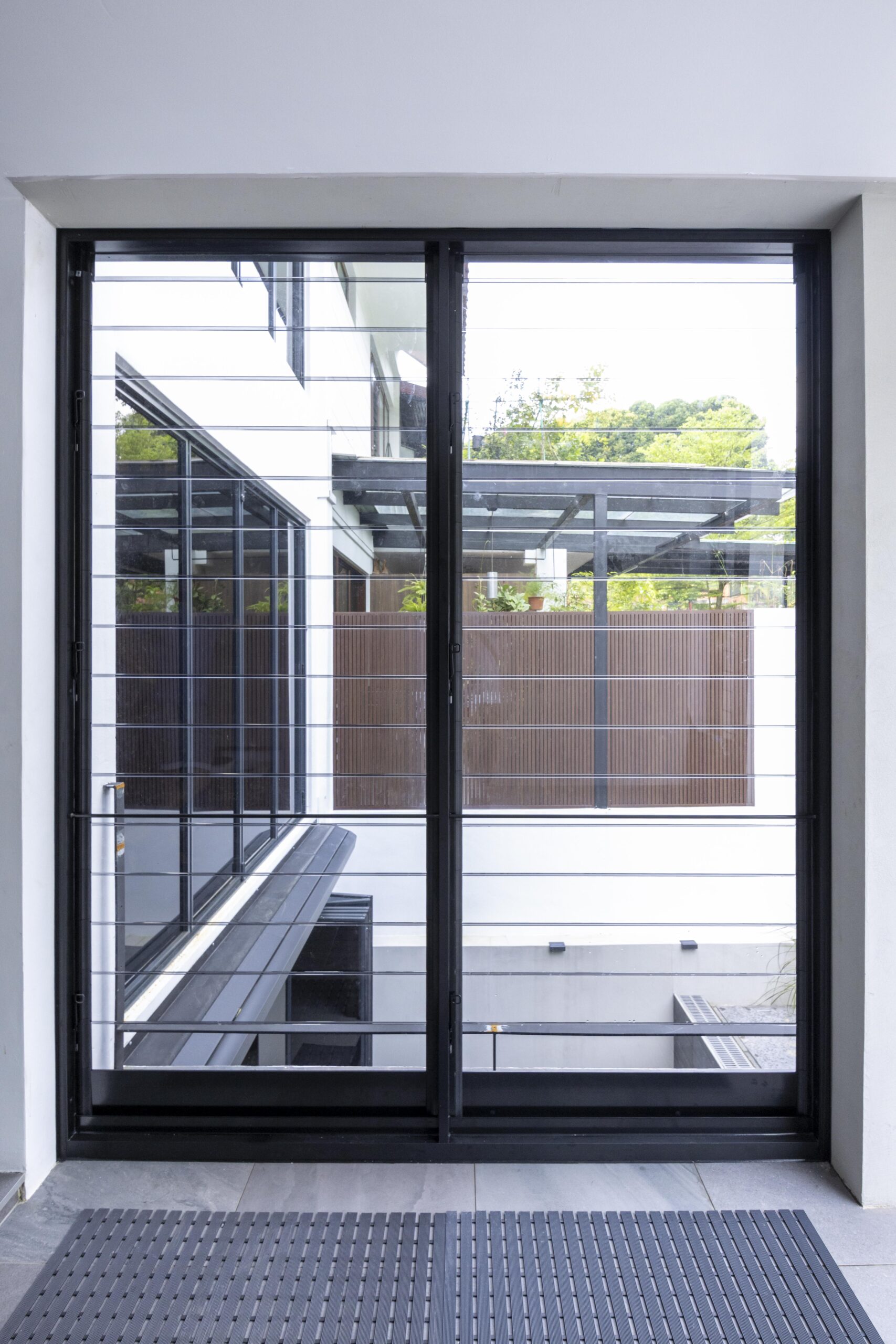 Custom Breezway Altair louvre windows installed at a car porch in Tagore Avenue with euro grey glass and black aluminium blade.