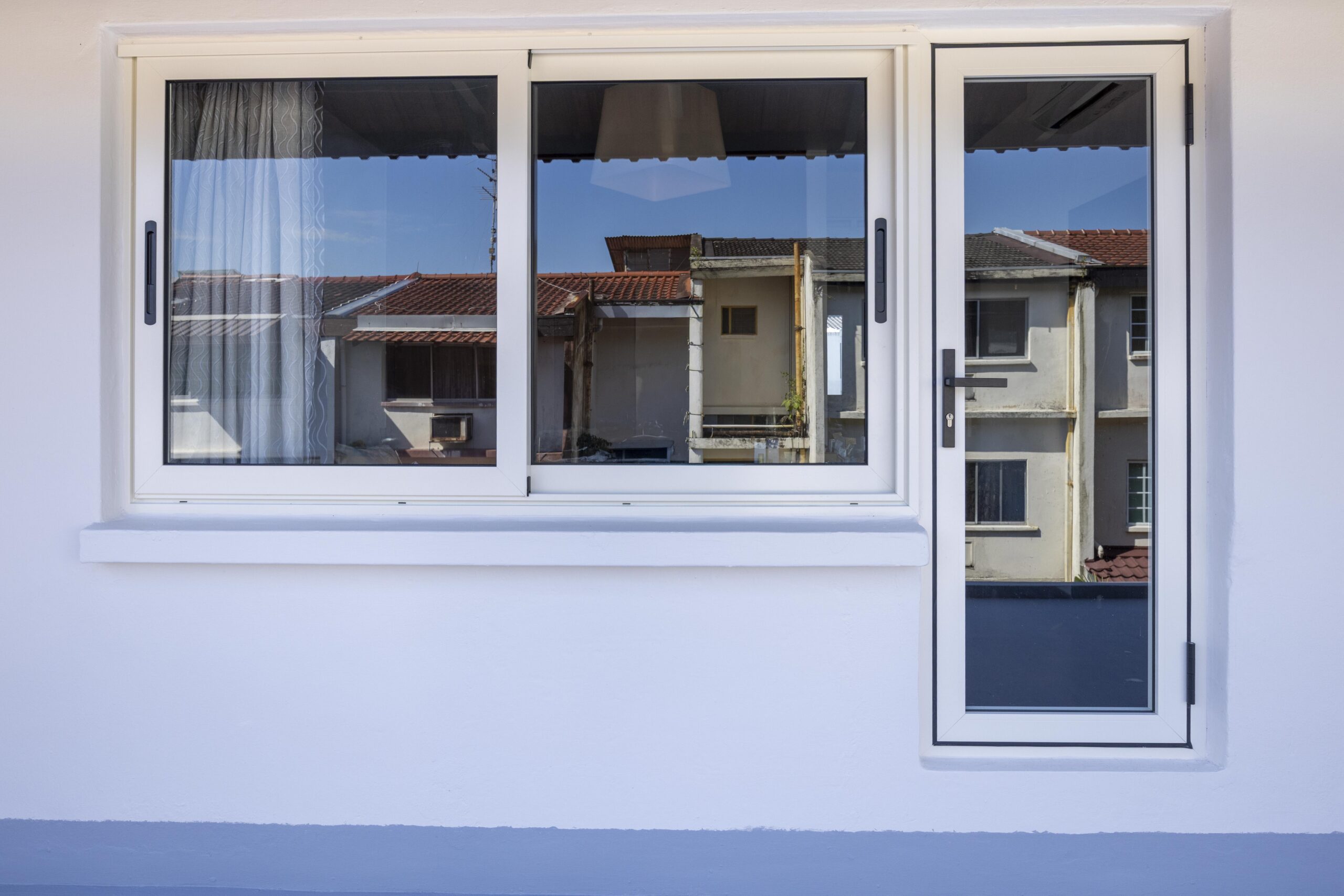 Integrated swing door beside Euro profile sliding window in the master bedroom.