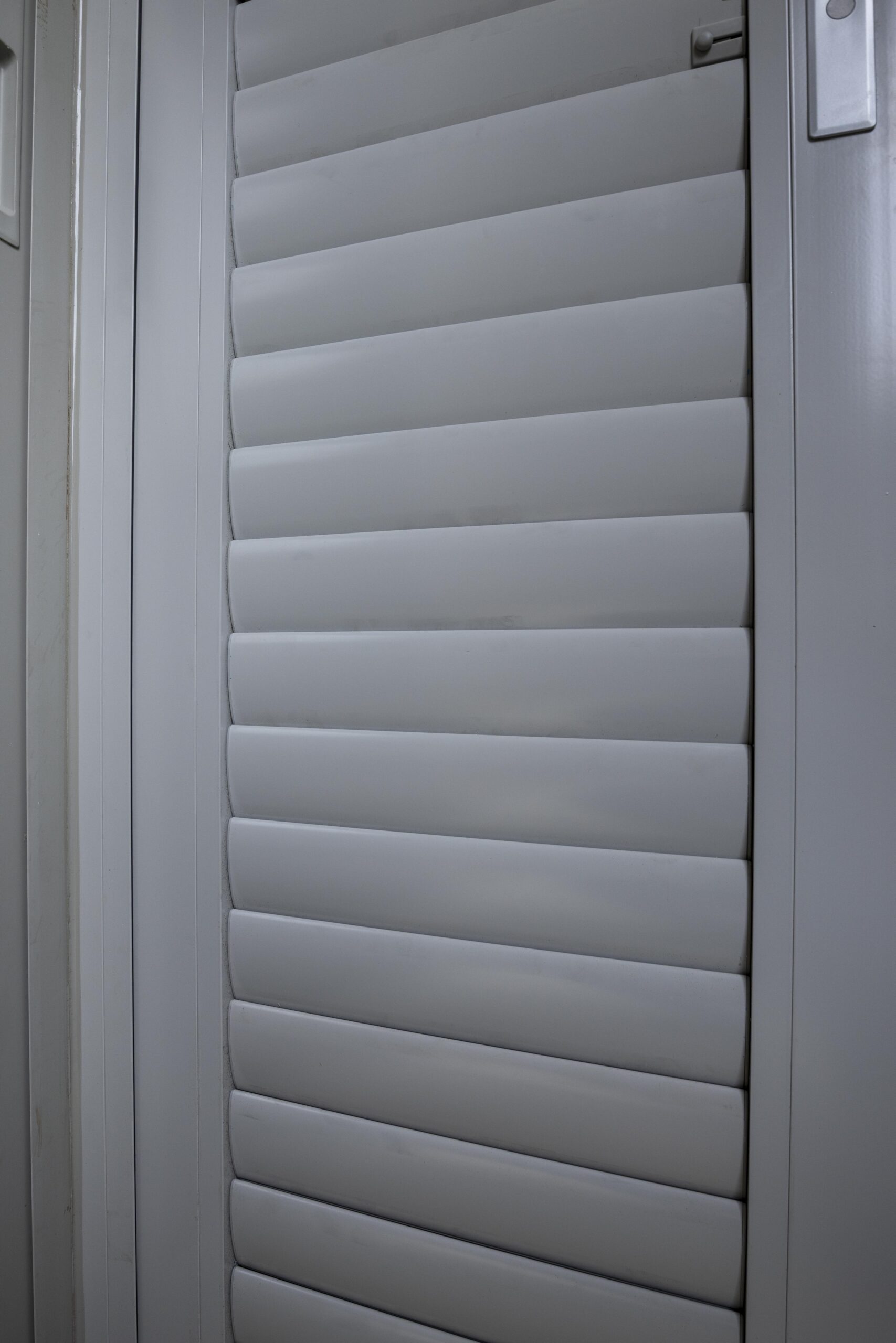 Adjustable aerofoil louvre sliding doors allowing ventilation and shading at the balcony