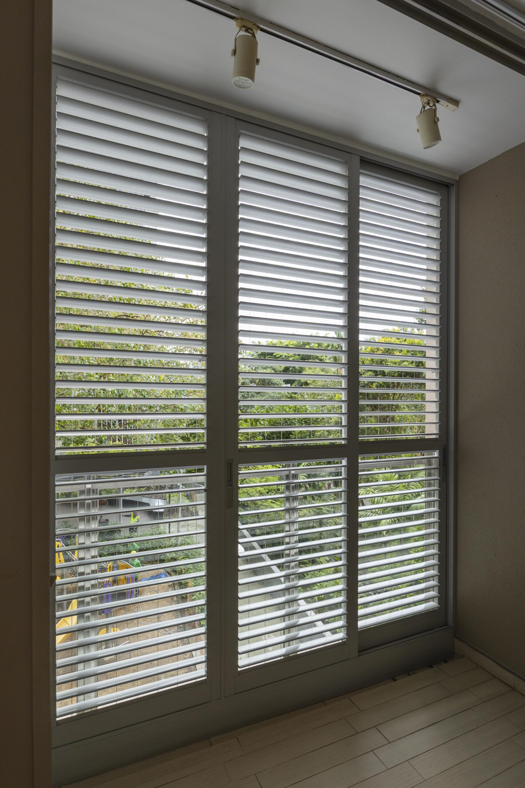 Sliding doors with powder coated adjustable aerofoil louvres installed along the balcony at Bartley Residence