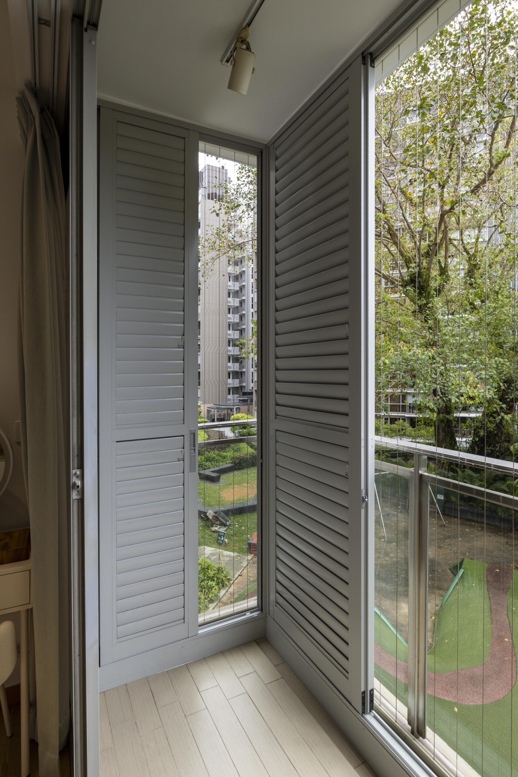Sliding doors with powder coated adjustable aerofoil louvres installed along the balcony at Bartley Residence