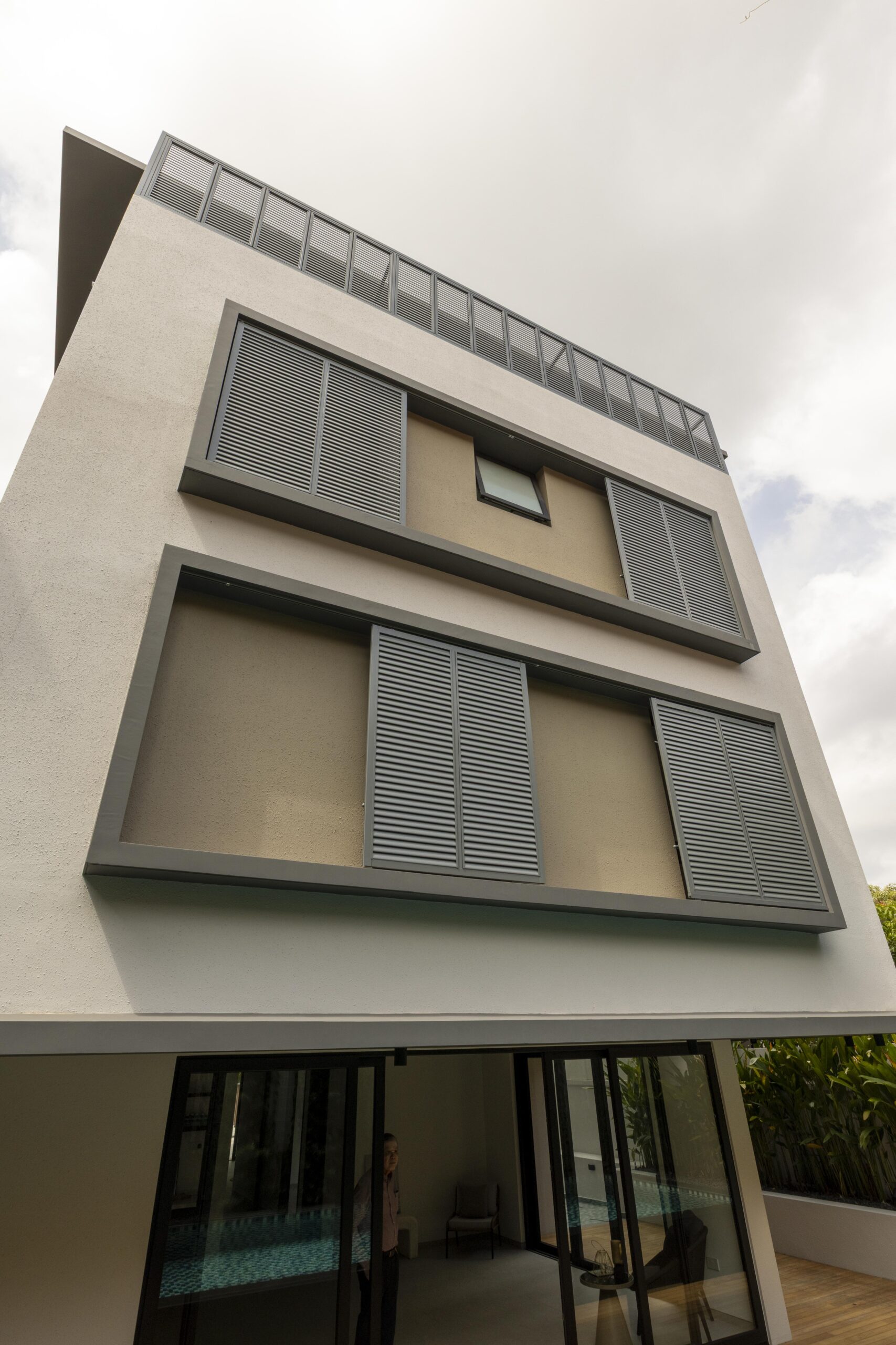 Aluminium aerofoil louvre screen installed in front of bedroom casement windows at Bedok Rise